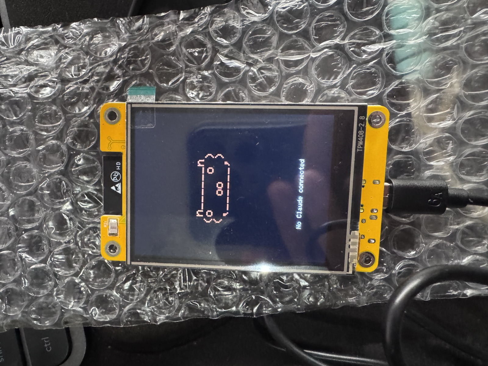 The CYD showing the ASCII capybara idling on a dark screen with 'No Claude connected'