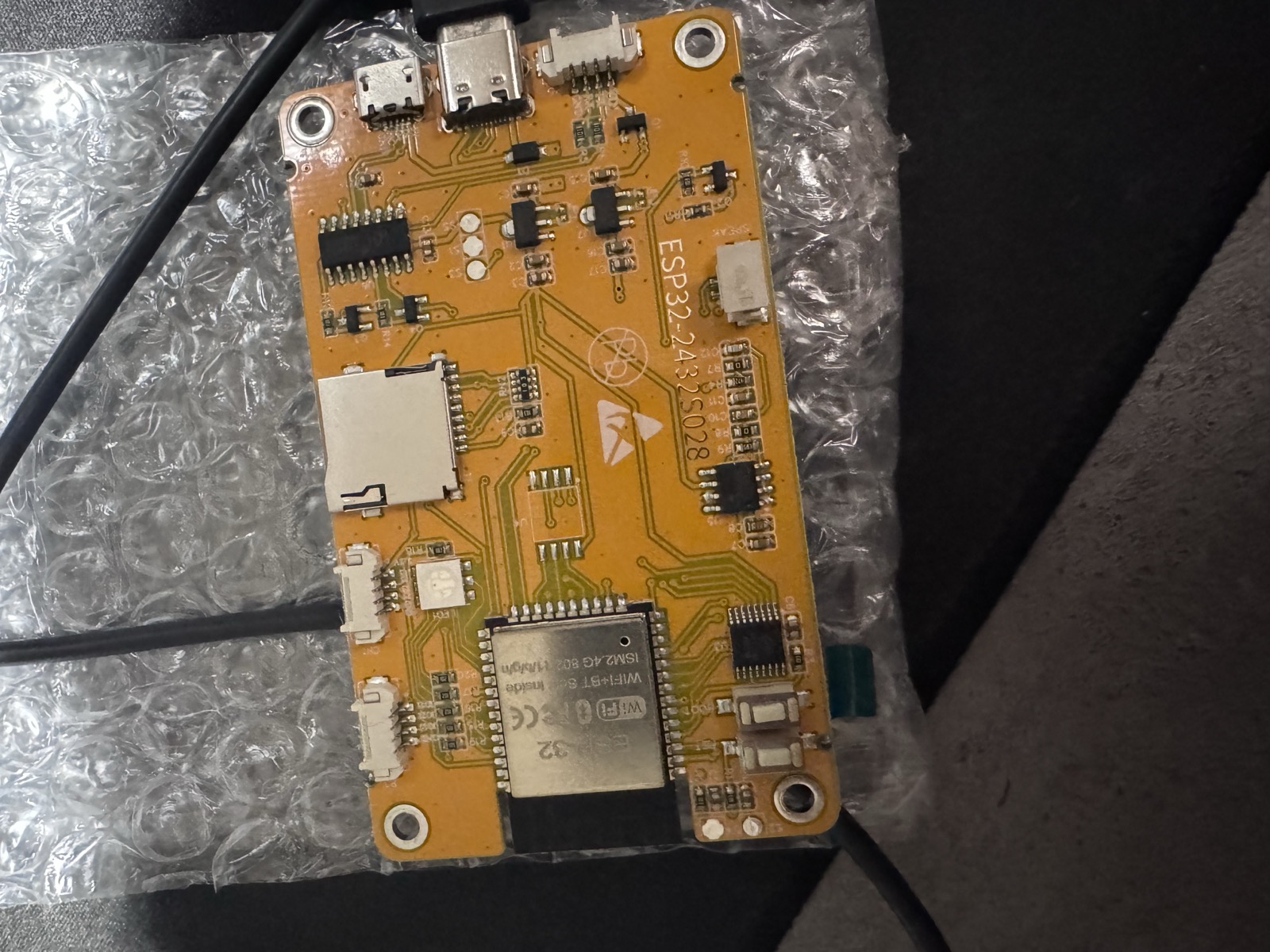 The bare ESP32-2432S028 board, yellow PCB with ESP32 module, microSD slot and dual USB ports